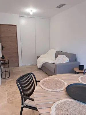 a living room with a couch and a table and chairs at Le Nid in Châteaurenard