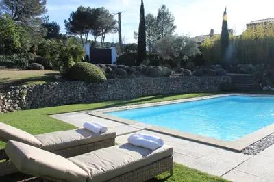 a swimming pool in a yard with two lounge chairs next to it at Bastide Lavandin - Stunning Provencal Escape in Ventabren