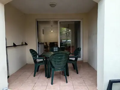 a green dining room table and chairs on a patio at Golf de pont royal in Mallemort