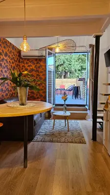 a living room with a table and a window at Duplex Aix Sunset Coeur centre historique in Aix-en-Provence