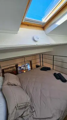 a bedroom with a large bed with a window at Duplex Aix Sunset Coeur centre historique in Aix-en-Provence