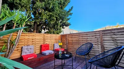 a patio with chairs and a table and a fence at Duplex Aix Sunset Coeur centre historique in Aix-en-Provence