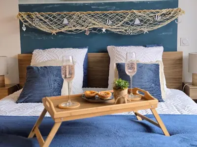 a table with two glasses and a tray of food on a bed at Studio Bleu Aix-en-Provence terrasse, piscine, parking in Aix-en-Provence