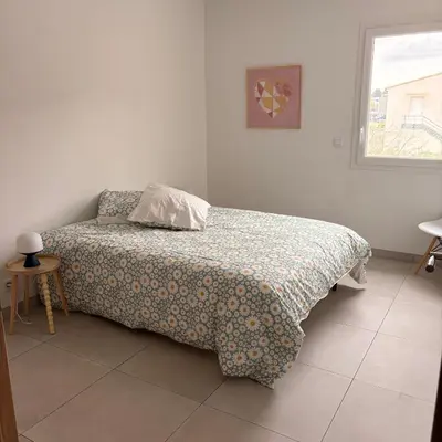 a bedroom with a bed with a comforter and a window at La terrasse in Charleval