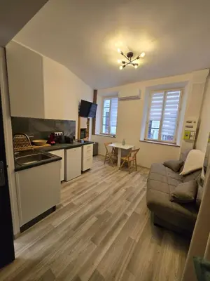 a kitchen and living room with a couch and a table at Studio Vacances super équipé in Carpentras