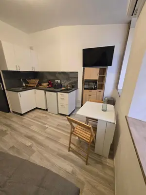 a kitchen with a white table and a table and a chair at Studio Vacances super équipé in Carpentras