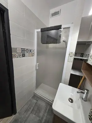 a white bathroom with a shower and a sink at Studio Vacances super équipé in Carpentras