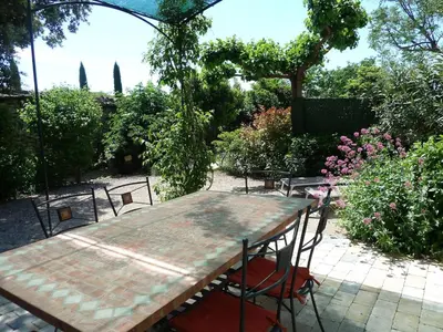 a table and chairs in a garden with flowers at Bastidon du Chene in Gordes