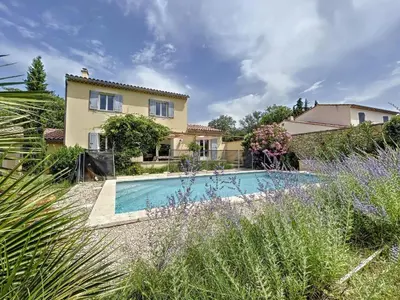 a villa with a swimming pool in front of a house at Maison LEA in Bédoin