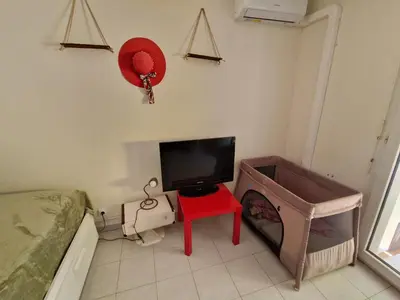 a bedroom with a tv and a red table and a bed at Studio DOUILLET in Aix-en-Provence