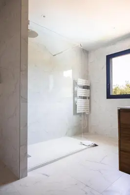 a bathroom with white marble walls and a window at Maison en Provence avec piscine in Éguilles