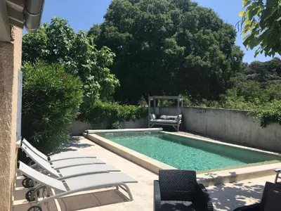 a swimming pool with chaises and chairs next to at Les Esperelles in Lagnes