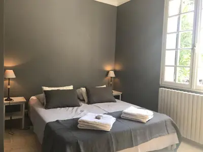 a bedroom with a bed and a table and a desk at Les Esperelles in Lagnes