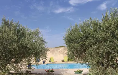 a swimming pool with trees in front of a building at Beautiful Home In Lancon De Provence in Lançon-Provence