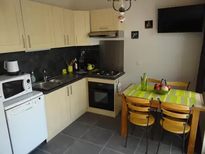 a kitchen with a table and a stove top oven at Duplex En Provence in Vedène