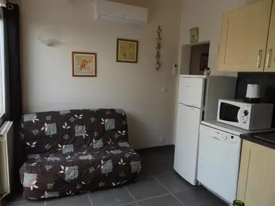 a kitchen with a couch with a microwave and a refrigerator at Duplex En Provence in Vedène