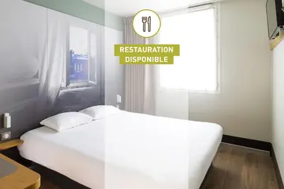 a bedroom with a white bed and a sign that reads restorationbuquerque at B&B HOTEL Salon de Provence in Salon-de-Provence