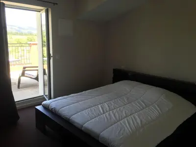a bedroom with a bed and a sliding glass door at Auberge Les Olivades in Mallemort