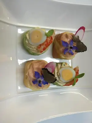a white plate with four pastries in a refrigerator at Auberge Les Olivades in Mallemort