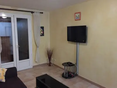 a living room with a flat screen tv on the wall at Auberge Les Olivades in Mallemort