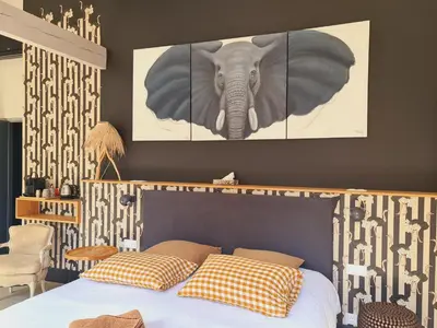 a bedroom with a bed with a picture of an elephant at La Magnanerie de l'Isle B&B in LʼIsle-sur-la-Sorgue