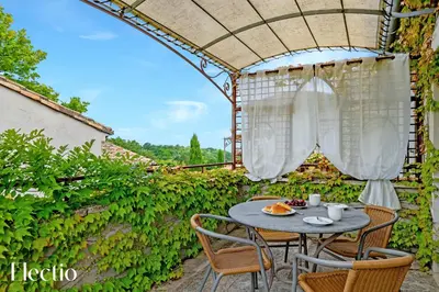 a patio with a table and chairs under a pergola at Résidence Les Petitons in Oppède