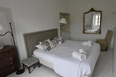 a bedroom with a white bed with towels on it at Clos De La Fontaine in Cabrières-dʼAvignon