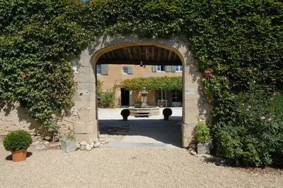 an archway in a building with a fountain in the background at Clos De La Fontaine in Cabrières-dʼAvignon