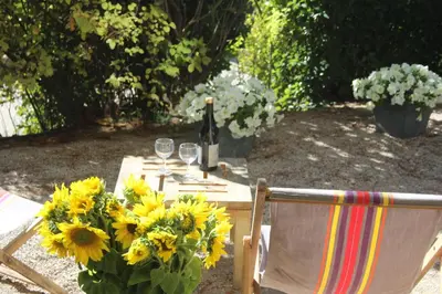 a table with a bunch of sunflowers and wine glasses at Le Mazet du Domaine in Gordes