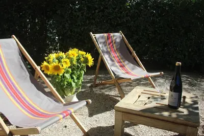 two chairs and a table with a bottle of wine and flowers at Le Mazet du Domaine in Gordes