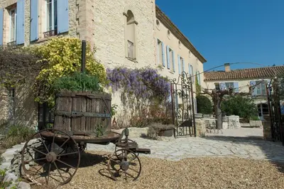a wooden cart with a planter on it in front of a building at Les Carmes and spa in Le Thor
