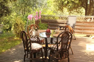 a table and chairs on a wooden deck at La Rousse in Roussillon