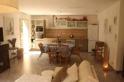 a living room with a table and a kitchen at La Rousse in Roussillon