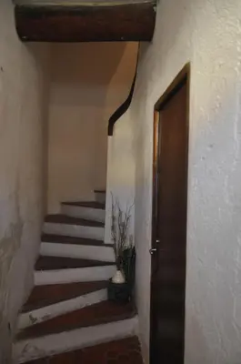 a hallway with stairs with a door and a vase at Appartement L'Atypique in Pertuis