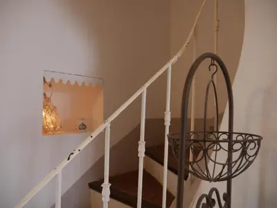 a staircase with a wrought iron chandelier in a house at L'Escarpolette in Saint-Saturnin-les-Apt