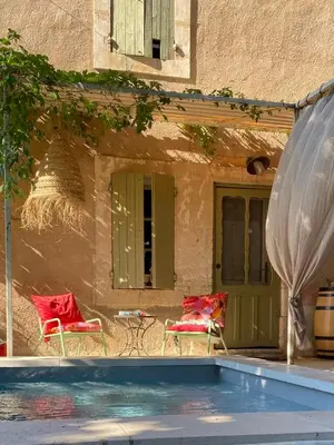 a patio with two chairs and a swimming pool at L'Escarpolette in Saint-Saturnin-les-Apt