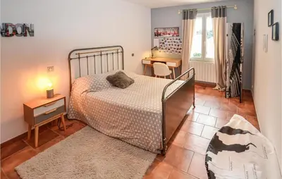a bedroom with a bed and a table and a desk at Awesome Home In Chateuneuf De Gadagne in Châteauneuf-de-Gadagne