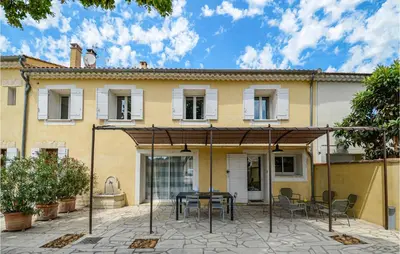 an outdoor patio with a table and chairs in front of a house at Awesome Home In Chateuneuf De Gadagne in Châteauneuf-de-Gadagne