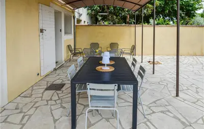 a black table and chairs on a patio at Awesome Home In Chateuneuf De Gadagne in Châteauneuf-de-Gadagne