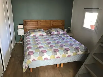 a bedroom with a bed with a colorful comforter and a window at Longo Mai in Apt