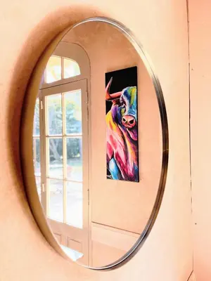 a mirror hanging on a wall with a painting at Hôtel Le Mas des Grès & Restaurant Sous les Platanes in Lagnes