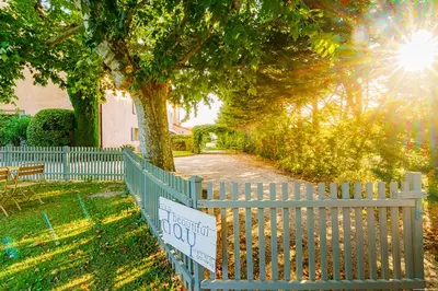 a white picket fence with a sign on it at Hôtel Le Mas des Grès & Restaurant Sous les Platanes in Lagnes