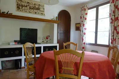 a dining room with a table and chairs and a television at L'Enclos in Aix-en-Provence