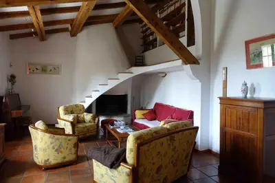 a living room with a couch and chairs and a staircase at L'Enclos in Aix-en-Provence
