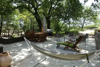 a hammock on a patio with a table and chairs at L'Enclos in Aix-en-Provence