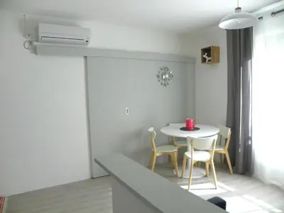 a small dining room with a white table and chairs at Provencal Vintage Cocoon in LʼIsle-sur-la-Sorgue