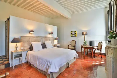 a bedroom with a bed and a table and chairs at Le Jardin de Mazan in Mazan