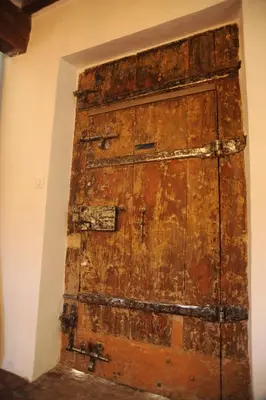 an old wooden door in the corner of a room at Le Jardin de Mazan in Mazan