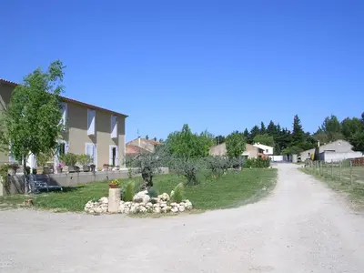 a dirt road with a house and a yard at La Sarriette - Chambres d'hôtes et gîte d'étape à Eygalières in Eygalières