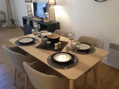 a dining room table with plates and wine glasses at Les Jardins de Mistral Apartment in Aix-en-Provence